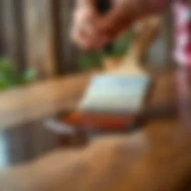Application Technique for Staining A close-up view of a brush applying stain to a wooden table, demonstrating the application technique